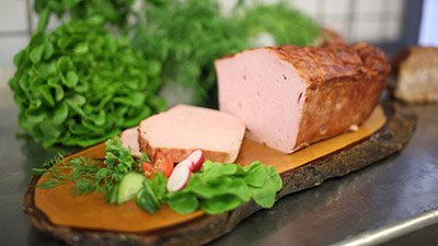 Unser Fleisch – Qualität Fleischwurst aus eigener Herstellung mit Salat und frischen Kräutern
